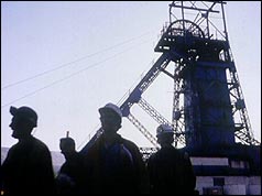 Silhouette of miners against pithead