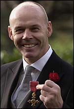 Clive Woodward shows off his OBE medal