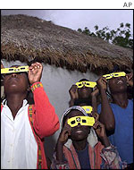 Villagers watching the eclipse through special glasses