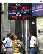 A woman looks at a currency exchange sign in Buenos Aires