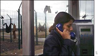 A refugee uses a phone at Sangatte