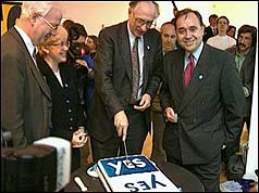 Donald Dewar cuts a cake to celebrate the 'Yes' vote for political referendum