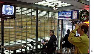 Customers in a Caracas restaurant watch a televised speech by Mr Chavez on Thursday