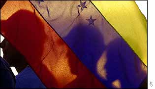 Protesters carry the national flag through Caracas on Wednesday