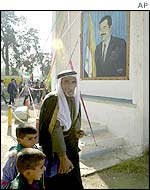 Iraqi family by portrait of Saddam Hussein