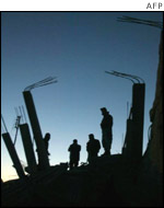 Palestinian men at the destroyed house in al-Bureij