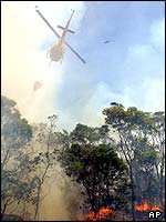 A helicopter drops water on a fire