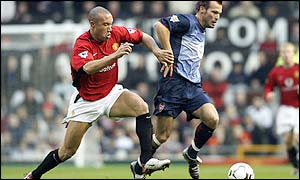 Mikael Silvestre pursues Arsenal's Fredrik Ljungberg 
