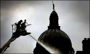 A firefighter trains his hose on buildings in Edinburgh's Cowgate