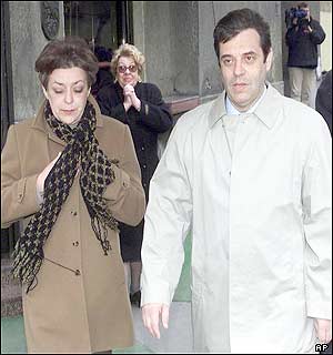 A woman clasps her hands in greeting, as Yugoslav President Vojislav Kostunica and his wife Zorica Radovic leave the polling station 