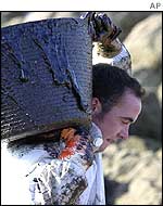 Volunteer with oil-filled bucket