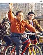 Lee Hoi-chang rides a bicycle with his supporters north of Seoul