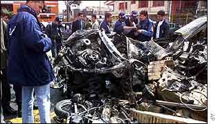 Explosives experts survey wreck of car 