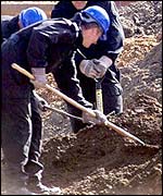 Police digging in mounds of earth