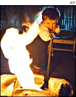 A Chechen refugee girls waits while her parents pack up their tent