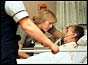 Two nurses at the bedside of an elderly patient