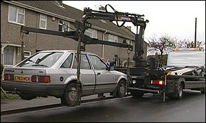 Car being lifted and towed