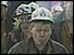 Miners wearing helmets leaving the colliery