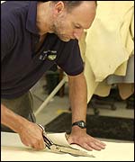 Worker cuts cow hide into shape