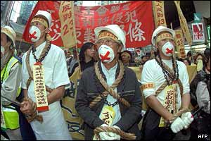 Protesters stand with their hands tied with rope 