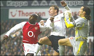 Arsenal's Sol Campbell is out-jumped for a high ball by Spurs captain Teddy Sheringham and Gunners' keeper David Seaman