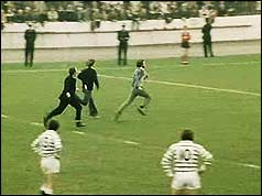 protesters make their point running across the pitch