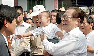 Chinese President Jiang Zemin (right) holds a Vietnamese baby whilst on a walkabout tour of the ancient Vietnamese trading port of Hoi An, 1 March 2002. 