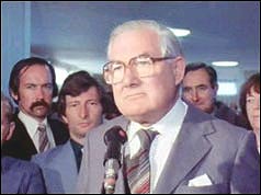 Callaghan speaking into microphone at Heathrow airport