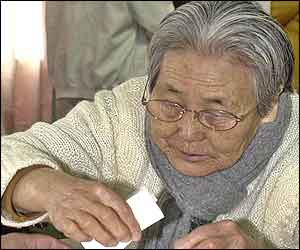 An elderly woman casts her ballot in presidential elections at a polling station in Jeju Island, South Korea