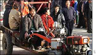 Farmers riding a tractor arrive as other voters stand in line to enter a polling station in Imsil County, South Korea