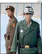A North Korean soldier (left) looks at a South Korea soldier standing guard on the North-South border, August 2002