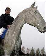 Champion jump jockey on the Desert Orchid statue at Kempton Park