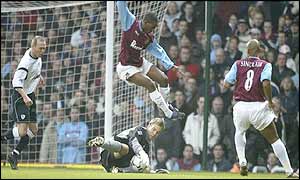 Jermain Defoe of West Ham leaps over Bolton goalkeeper Jussi Jaaskelainen