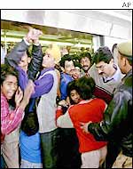 Passengers hang on to the train