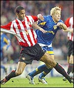 Phil Babb (left) tussles with Alan Smith