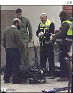 Investigators stand around body of one of the settlers