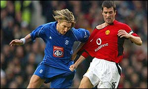 Manchester United captain Roy Keane challenges Birmingham's Robbie Savage