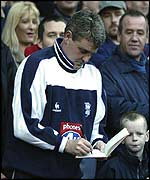 Former Man Utd captain Steve Bruce signs an autograph for a young fan