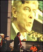 Houllier looks on as Wenger looks down