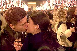 Two revellers kiss on the Champs Elysees in Paris
