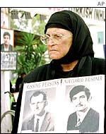 A Greek Cypriot woman holding pictures of alleged victims of Turkey's 1974 invasion