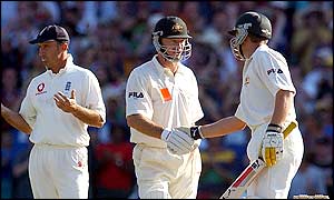 Steve Waugh is congratulated by Adam Gilchrist after reaching 10,000 Test runs