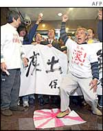 A protester stamps on a makeshift Japanese imperial flag as a group stages a demonstration ouside the Japanese consulate in Hong Kong 