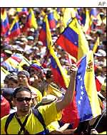 Opposition supporters wave flags as they parade down to Fuerte Tiuna in Caracas