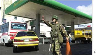 A Venezuelan army soldier directs traffic at the entrance to a gas station in Caracas