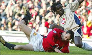 Linvoy Primus of Portsmouth fouls Ryan Giggs to give away a penalty