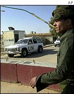 Iraqi soldier watches UN inspectors
