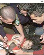 Rescue workers and bystanders attend to an injured woman