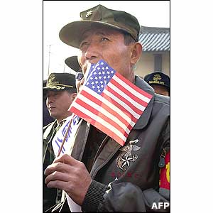 A South Korean marine veteran holds an US flag during an anti-North Korean and pro-US demonstration 8 January 2003 in front of Osan US air base