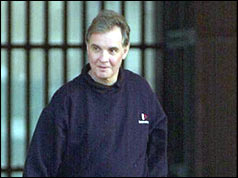 Jonathan Aitken with prison gates behind him